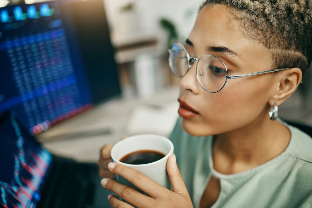 Computer, coffee and professional woman with stock market analysis, crypto audit or monitor equity