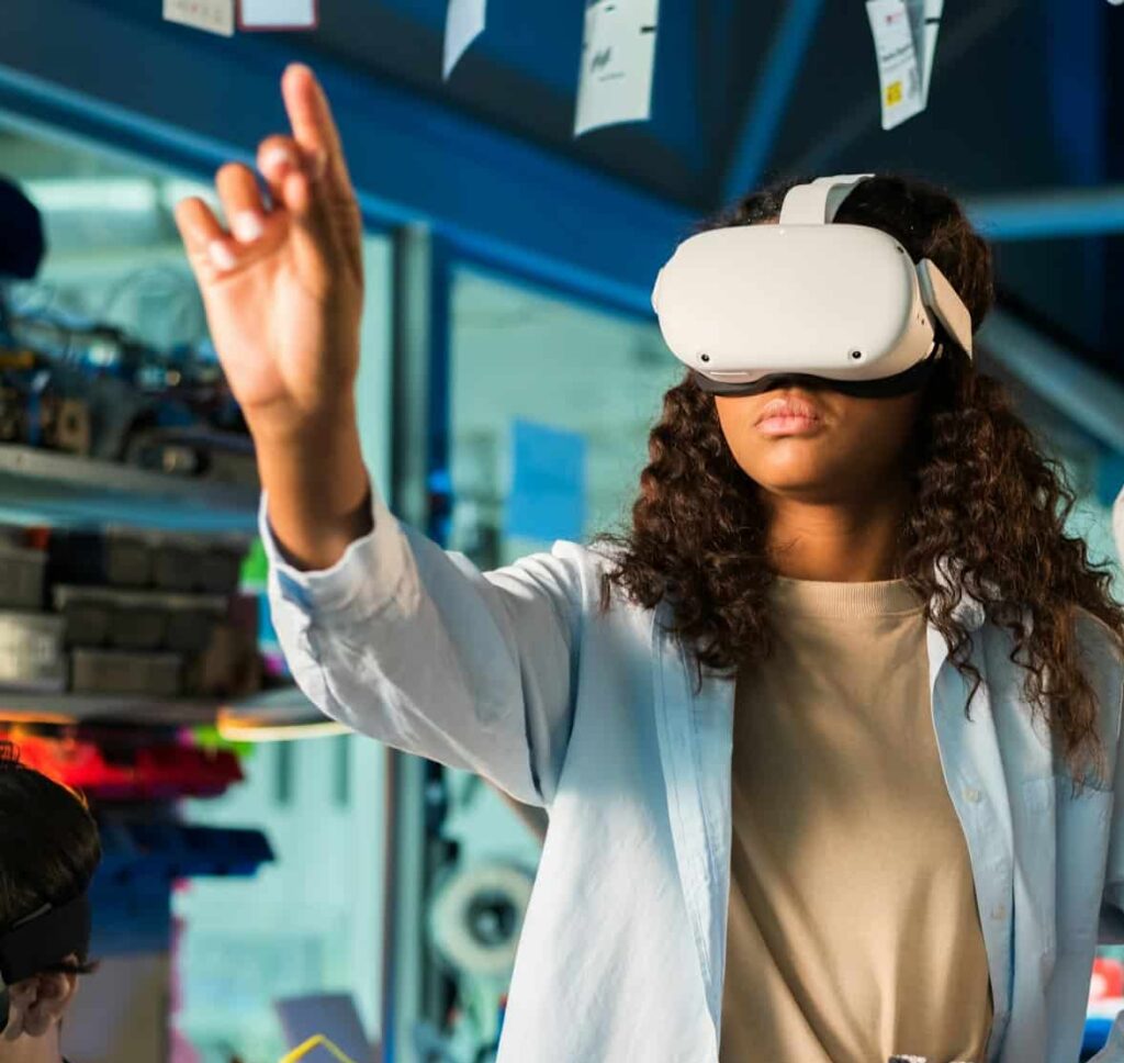 Two young women in VR glasses doing experiments in robotics in a laboratory